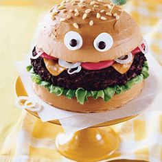 a hamburger with googly eyes sitting on top of a table