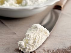 a spoon full of cottage cheese on a wooden table