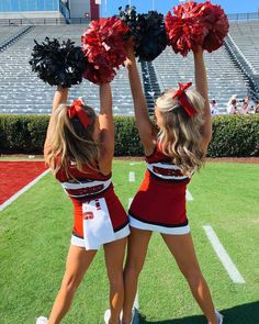 two cheerleaders holding up their pom poms