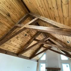 a large room with wooden ceilings and windows