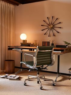 an office chair sits in front of a desk with a clock on the wall