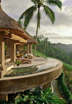 a house on top of a hill with trees and mountains in the background