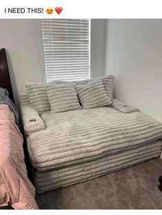 a bed that is in the corner of a room next to a window with blinds