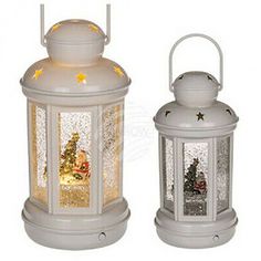 two white lanterns sitting next to each other with christmas decorations on the front and side