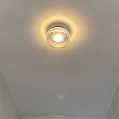 a bathroom with a toilet and bathtub under a light on the ceiling above it