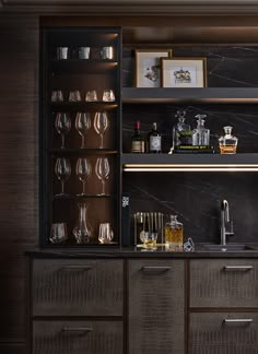 a bar with wine glasses and liquor bottles on the top shelf, along with other items