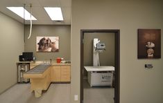 an office hallway with pictures on the wall and a table in front of it that is empty