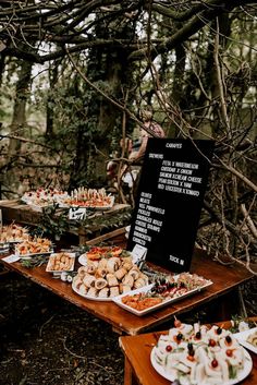 a table filled with lots of food in the woods