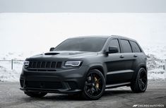 a black jeep parked in front of a snow covered mountain