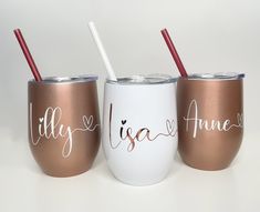 three personalized tumblers with straws in them on a white tablecloth background