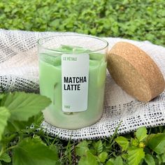 a green candle sitting on top of a white cloth next to a piece of bread