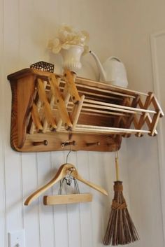 a wooden rack with brooms and other items hanging on it's side wall