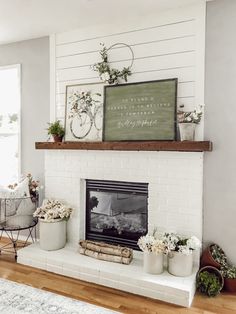 a white brick fireplace with flowers and plants on top