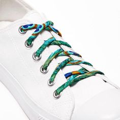 a pair of white shoes with colorful laces on them