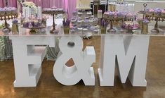 a large white sign that says love and m is on the floor in front of some desserts