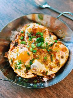 two fried eggs on top of rice in a bowl