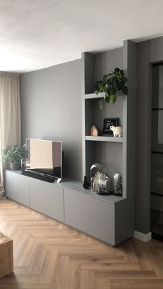 a living room filled with furniture and a flat screen tv on top of a shelf