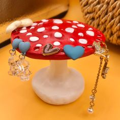 a red and white mushroom with hearts on it's top sitting on a table