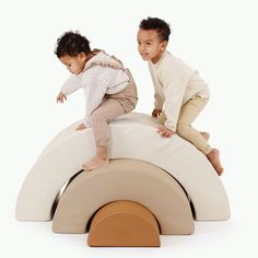 two young children are playing on a white and tan play structure that is shaped like an elephant