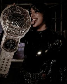 a woman in latex holding up a wrestling belt