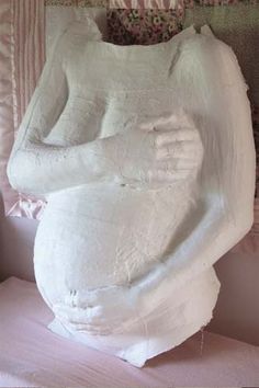 a large white sculpture sitting on top of a bed