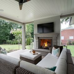 an outdoor living area with couches and a fireplace