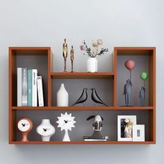 a shelf filled with vases, books and other decorative items on top of it