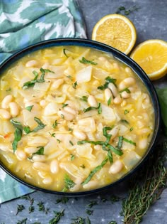 a bowl filled with soup next to sliced lemons