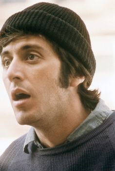 a man with a surprised look on his face wearing a knitted hat and looking off to the side