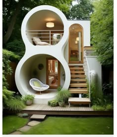 an unusual house in the middle of a garden with stairs leading up to it's second floor