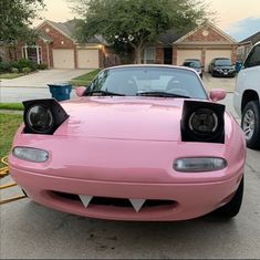 a pink car parked in front of a house