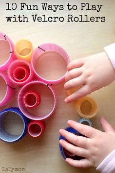 two children are playing with paper cups on the table and one child is reaching for them