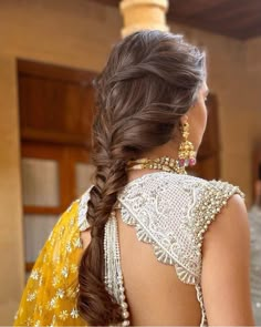 a woman with long hair wearing a yellow sari and gold jewelry on her neck