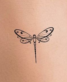 a woman's stomach with a small dragonfly tattoo on the back of her belly