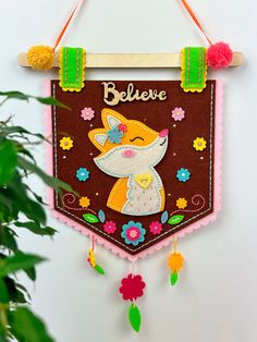 a wall hanging decoration with a fox on it's side and the words believe