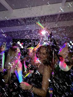 several women are standing in front of bubbles and confetti on the dance floor