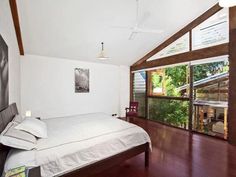 a bedroom with wood floors and white walls