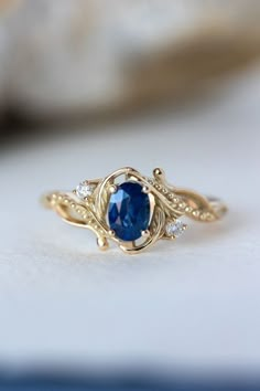 a gold ring with a blue sapphire and diamond accents