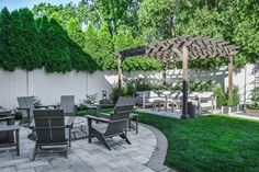 an outdoor patio with chairs, table and grill