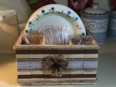 a wooden box filled with dishes and utensils