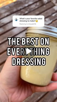 a person holding a mason jar with the text, the best on everything dressing