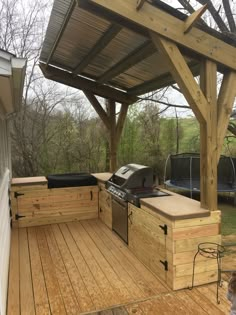 a wooden deck with an outdoor kitchen and grill