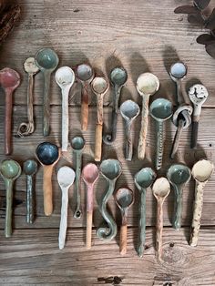 many spoons are lined up on a wooden table