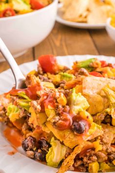 a white plate topped with taco salad and tortilla chips