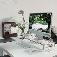 a computer monitor sitting on top of a white desk next to a keyboard and mouse