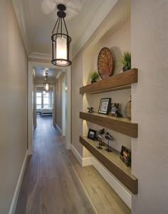 a long hallway with shelves and pictures on the wall, along with a lantern hanging from the ceiling