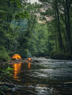 an orange tent sitting on top of a river in the woods next to a forest