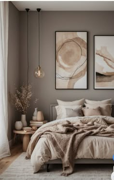 a bedroom with two paintings hanging above the bed