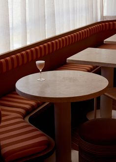 a wine glass sitting on top of a table next to two chairs and a window