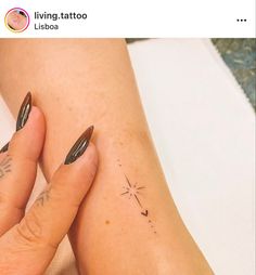 a woman's legs with tattoos on them and her hand holding the other leg